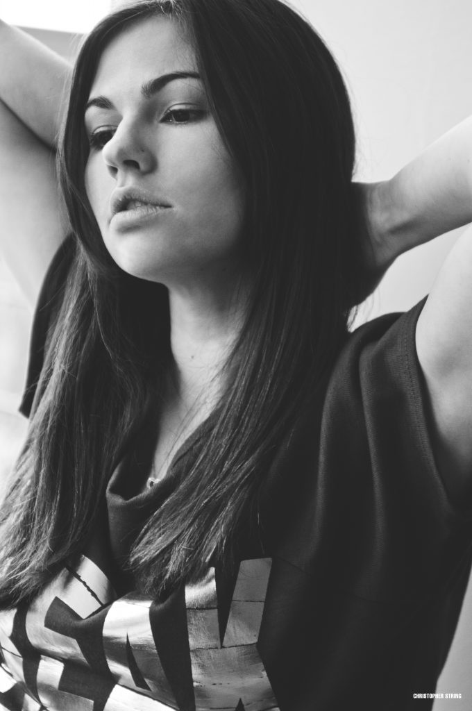 Woman holding her hair looking down in black and white