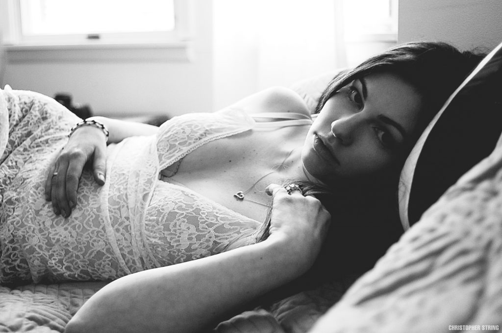 Woman in black and white laying on bed