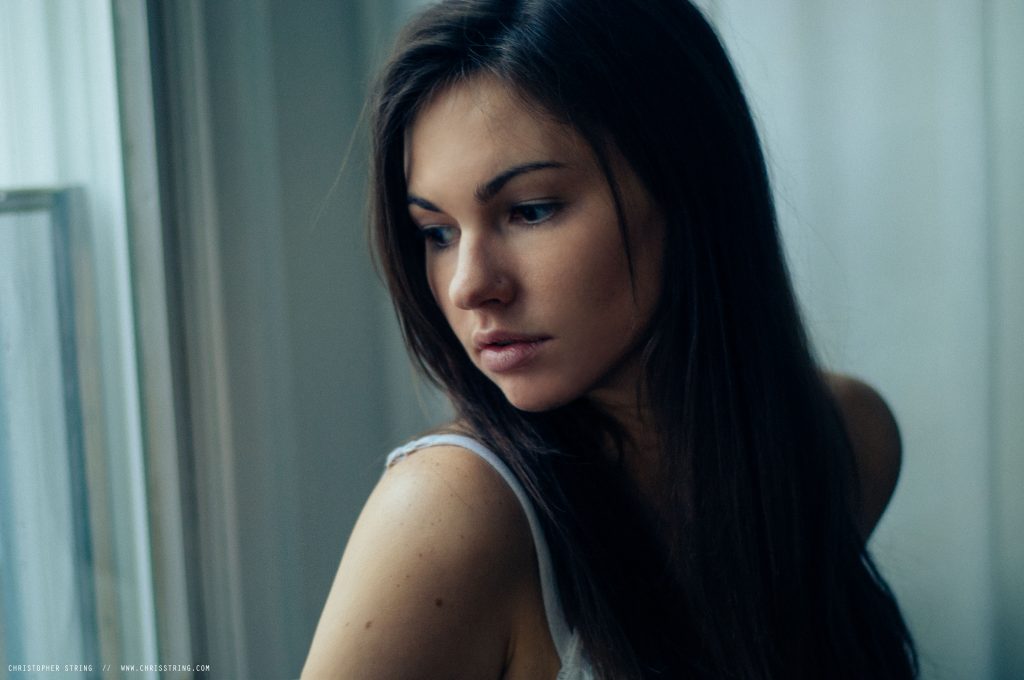 Woman looking out of window over her shoulder