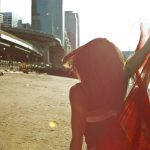 Woman in Red Scarf dances on the beach by Christopher String