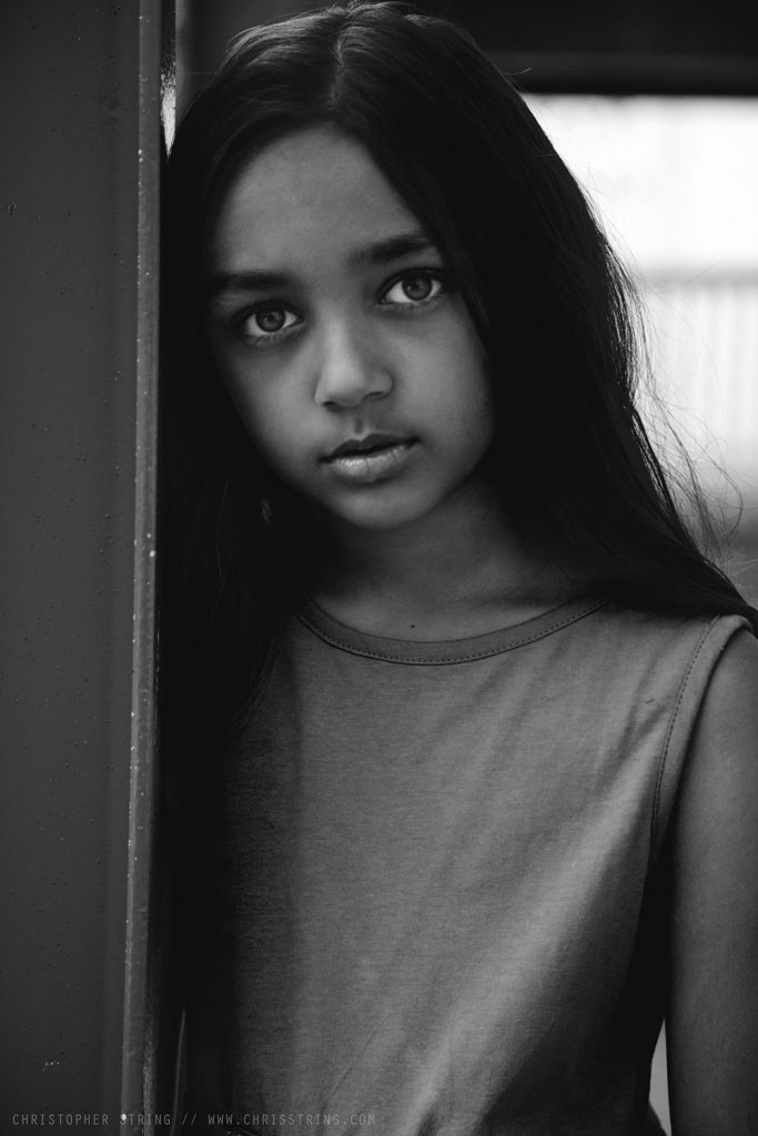 Young girl with dark hair in portrait session by Christopher String